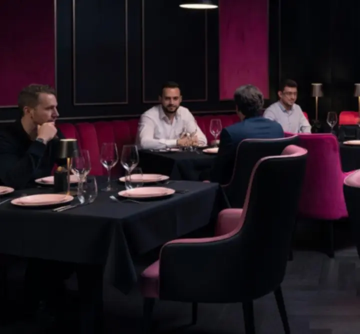 Elegáns esti éttermi enteriőr a Pest Dining Guide-ban, finoman megvilágított asztalokkal.
